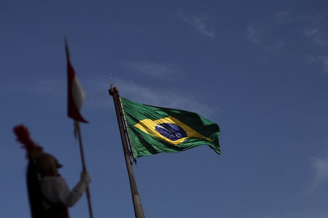 A soldier of the presidential guard stands at the Planalto Palace as the Brazilian flag flutters in the background, in Brasilia, Brazil July 31, 2025. REUTERS/Adriano Machado/File Photo