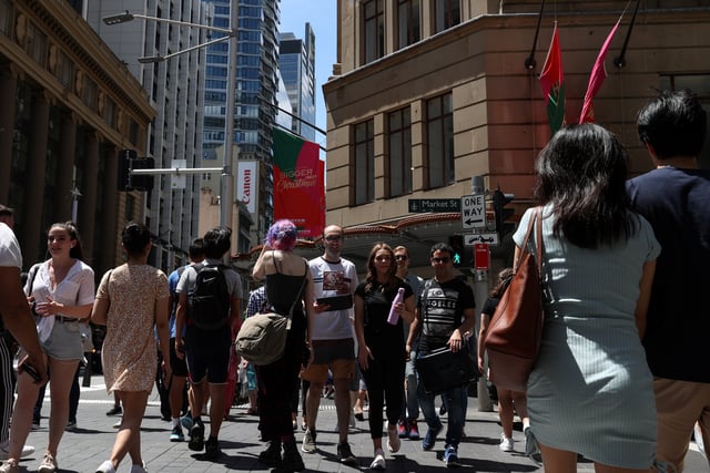 People cross a busy street in the city centre of Sydney, Australia, December 17, 2020. REUTERS/Loren Elliott/File Photo
