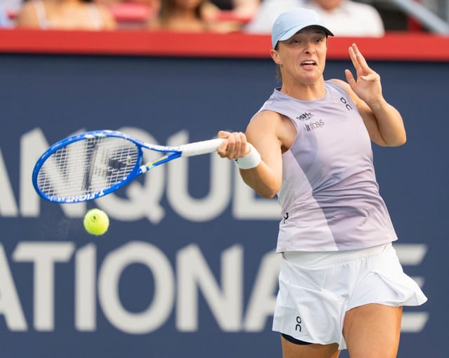 La polaca Iga Swiatek devuelve una bola a la danesa Clara Tauson durante el partido de octavos de final del torneo de tenis femenino National Bank Open en Montreal, el domingo 3 de agosto de 2025. (Christinne Muschi/The Canadian Press via AP)