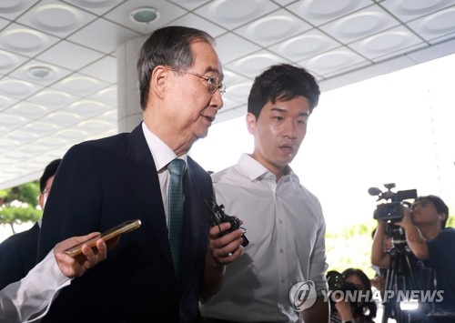 Former Prime Minister Han Duck-soo (L) arrives at special counsel Cho Eun-suk's office in southern Seoul to undergo questioning on Aug. 19, 2025. (Yonhap)
