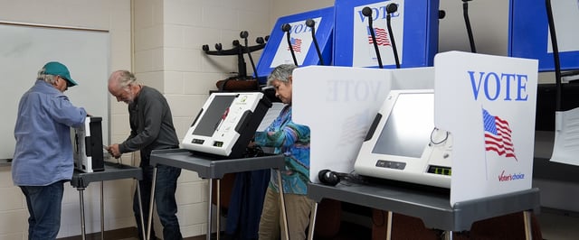 Poll workers set up ballot-marking machines at an early in-person voting site at Asheville-Buncombe Technical Community College, Wednesday, Oct. 16, 2024, in Marshall, N.C. (AP Photo/Stephanie Scarbrough)