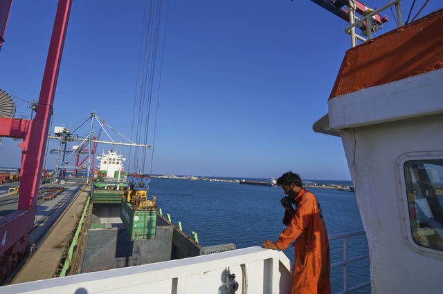Jalal Uddin, electrical and technology officer aboard a Panamanian-flagged ship watches as containers filled with humanitarian aid for the people of Gaza are being loaded aboard the vessel at Cyprus' main port in Limassol, on Monday, Aug. 18, 2025. (AP Photo/Petros Karadjias)