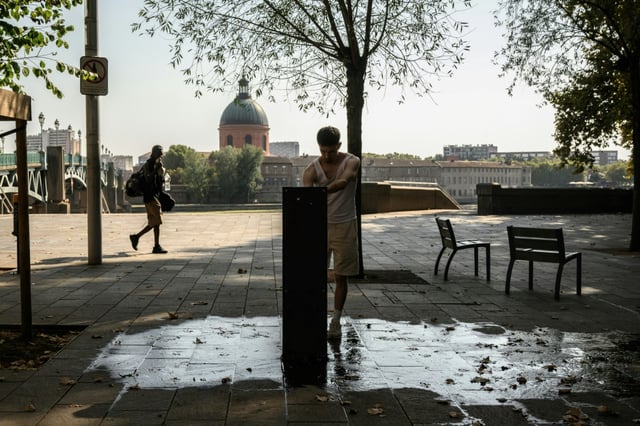 Un homme devant une fontaine près de la Garonne lors d'une vague de chaleur à Toulouse, le 15 août 2025
