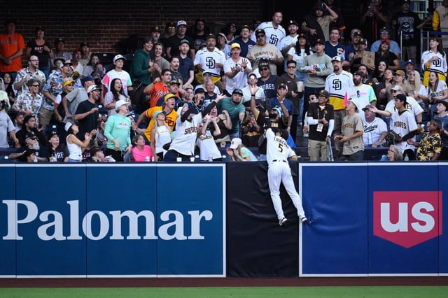 Ramon Laureano (5), jardinero izquierdo de los Padres de San Diego, no logra atrapar un jonrón de dos carreras de Wilmer Flores, de los Gigantes de San Francisco, durante la primera entrada del juego de béisbol de Grandes Ligas, el lunes 18 de agosto de 2025, en San Diego. (AP Foto/Orlando Ramirez)