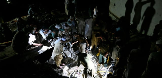 Sans électricité, des villageois et secouristes fouillent les décombres de maisons dévastées par la mousson, à la recherche de survivants ou de dépouilles de victimes, dans le village de Dolari, dans le nord du Pakistan, le 18 août 2025