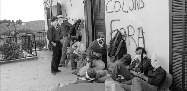 Des autonomistes corses masqués et armés devant une cave viticole pendant une prise d'otages à Aléria, le 21 août 1975 en Haute-Corse