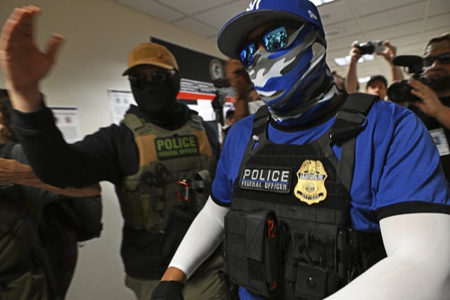 Masked federal agents walk through the halls outside the immigration courtrooms of Federal Plaza in New York City.