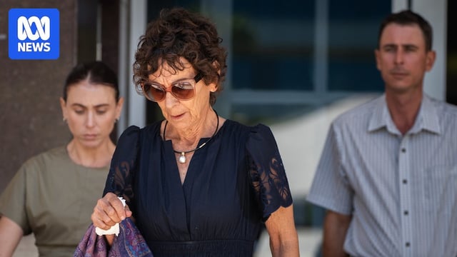 a woman wearing a navy blue dress and large sunglasses exiting court