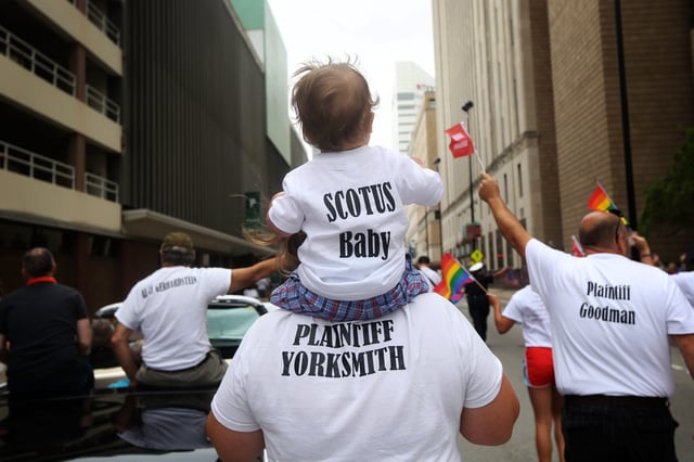 Pam Yorksmith, who was among the plaintiffs in the Obergefell v. Hodges Supreme Court case that legalized same-sex marriage nationwide, carries her child in the 2015 Cincinnati Pride Parade.