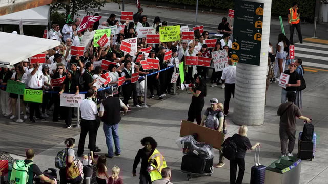 Passagiere gehen am Vancouver International Airport in Richmond an streikenden Flugbegleitern von Air Canada vorbei.