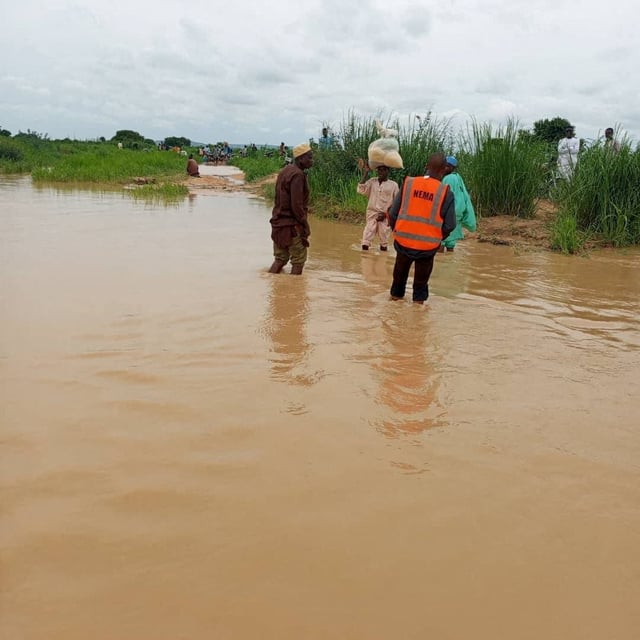A member of the National Emergency Management Agency stands in water as search and rescue operations continue following a boat accident, in a place given as Sokoto State, Nigeria, in this handout image released on August 17, 2025. National Emergency Management Agency, Nigeria/Handout via REUTERS
