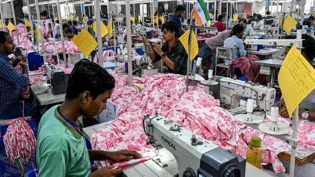 Employees stitch clothing material for dresses at the apparel manufacturing unit at Bhiwandi in the Thane district of India's Maharashtra state on July 30, 2025. Indian exporters were bracing for higher US tariffs to kick in on July 30 as prospects dimmed for an interim trade deal between New Delhi and Washington before the August 1 deadline. (Photo by Indranil MUKHERJEE / AFP)