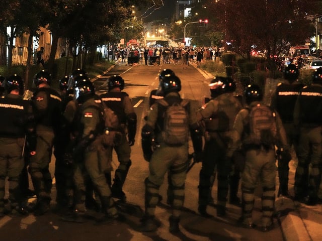 Serbische Gendarmeriebeamte jagen Demonstranten während einer Anti-Regierungs-Demonstration. 