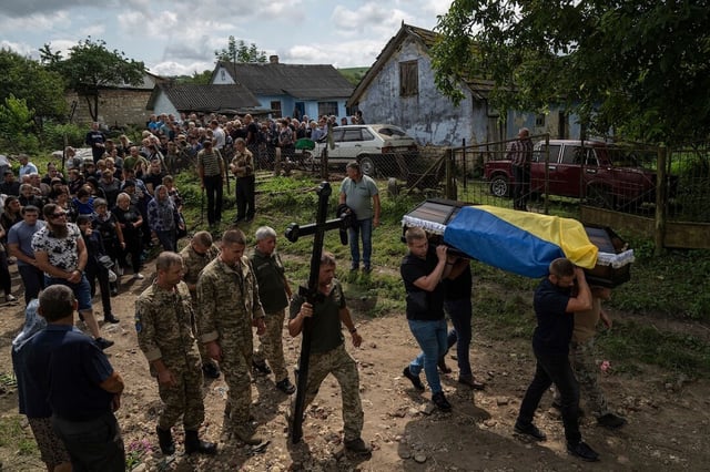 People carry the coffin of Ukrainian serviceman Bohdan Kobylianskyi who was killed in Donbas, during funeral ceremony in Dusaniv, Ukraine, Saturday, July 22, 2023. (AP Photo/Evgeniy Maloletka)