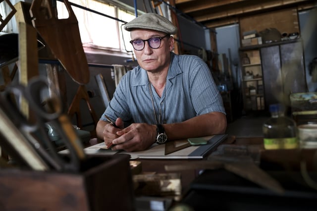 Oliver Masucci, Schauspieler in der Rolle des Rudertrainers Klaus Adam, sitzt am Set in seiner Werkstatt im Bootshaus des Ratzeburger Ruderclubs.