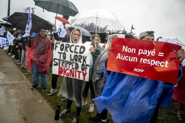 Des hôtesses et stewards manifestent devant l'aéroport Pierre-Elliott Trudeau à Montréal, au Québec, le 17 août 2025 au Canada