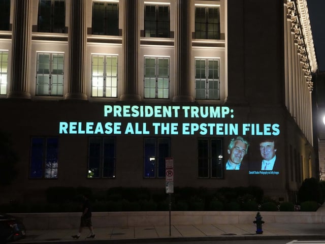 18.07.2025, USA, Washington: Diese Aufforderung an US-Präsident Trump wird im Juli 2025 als Projektion an eine Hausfassade am Hauptsitz der US-Handelskammer geleuchtet. Die Demonstranten fordern die Veröffentlichung aller Unterlagen zum Fall Epstein.