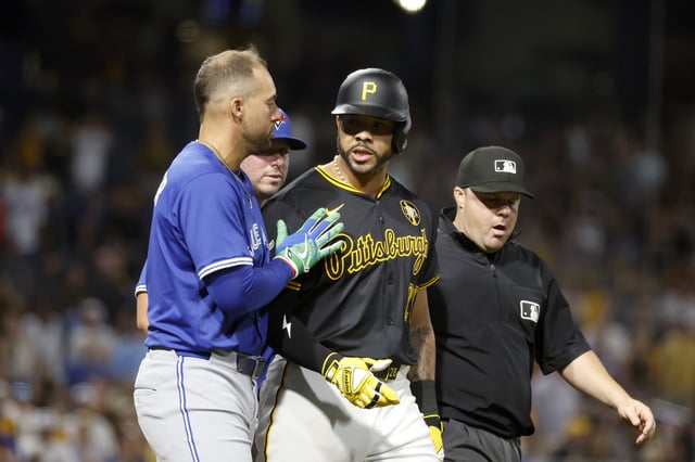 PITTSBURGH, PA - AUGUST 18: George Springer #4 of the Toronto Blue Jays walks with Tommy Pham #28 of the Pittsburgh Pirates after flipping his bat following a walk in the seventh inning at PNC Park on August 18, 2025 in Pittsburgh, Pennsylvania. (Photo by Justin K. Aller/Getty Images)