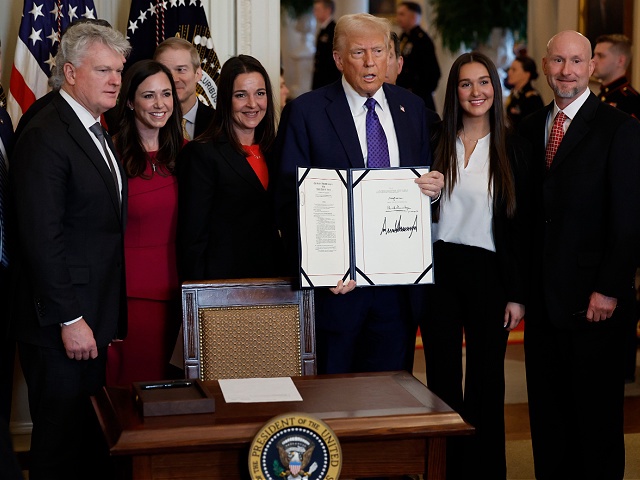 WASHINGTON, DC - JANUARY 29: Surrounded by members of Congress and the family of Laken Riley, U.S. President Donald Trump poses with the signed Laken Riley Act, the first piece of legislation passed during his second term in office, in the East Room of the White House on January 29, 2025 in Washington, DC. Jason Riley and Allyson Philips, the parents of 22-year-old Laken Riley, a University of Georgia nursing student who was murdered in 2024 by an undocumented immigrant, attended the signing ceremony. Among other measures, the law directs law enforcement authorities to detain and deport immigrants who are accused but not yet convicted of specific crimes, if they are in the country illegally. (Photo by Chip Somodevilla/Getty Images)