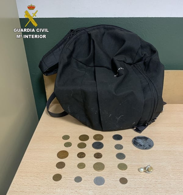 La mochila que portaba el detenido con una joya y monedas antiguas.
