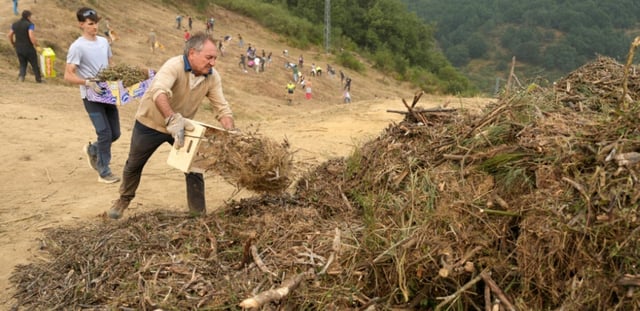 Des habitants réalisent des travaux de déboisement en prévision d'un possible arrivée du feu provenant de l'incendie du parc national des Picos de Europa, dans la ville de Riano, en Castille-et-León, en Espagne, le 18 août 2025