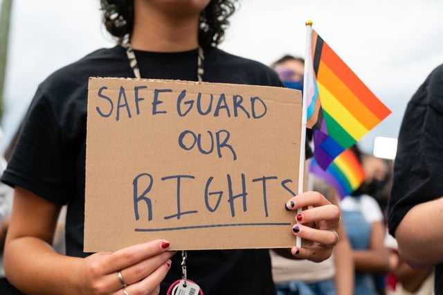 A student holds a sign reading, "safeguard our rights," during a rally.