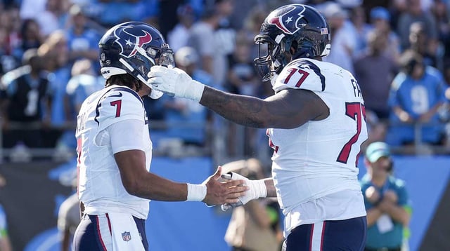 Oct 29, 2023; Charlotte, North Carolina, USA; Houston Texans offensive tackle George Fant (77) congratulates quarterback C.J. Stroud (7) after his score against the Carolina Panthers during the second half at Bank of America Stadium.