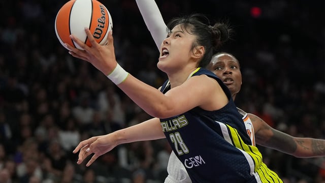 Jul 7, 2025; Phoenix, Arizona, USA; Dallas Wings center Li Yueru (28) drives on Phoenix Mercury forward Natasha Mack (4) in the first half at Footprint Center. Mandatory Credit: Rick Scuteri-Imagn Images