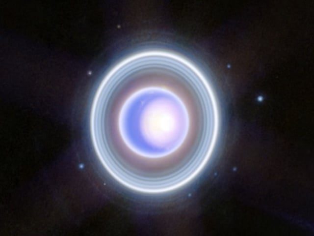 ESPACIO, 18/12/2023.-El telescopio espacial James Webb ha dirigido su mirada hacia el inusual y enigmático gigante helado Urano, capturando un mundo dinámico con anillos, lunas, tormentas y otras características atmosféricas, incluido un casquete polar 'estacional'. La imagen amplía una versión en dos colores publicada a principios de este año, añadiendo una cobertura adicional de longitudes de onda para obtener una visión más detallada, informan en sendos comunicados la Agencia Espacial Europea (ESA) y la agencia estadounidense NASA. Debido a su "exquisita sensibilidad", Webb captó los tenues anillos interior y exterior de Urano, incluido el escurridizo anillo Zeta, el anillo extremadamente tenue y difuso más cercano al planeta. La imagen, tomada por la cámara NIRCam, también muestra 9 de las 27 lunas del planeta. Son los puntos azules que rodean sus anillos (en el sentido de las agujas del reloj, empezando por las dos: Rosalinda, Puck, Belinda, Desdémona, Crésida, Bianca, Porcia, Jul