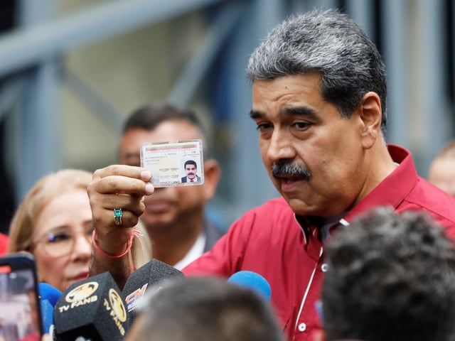 Venezuela's President Nicolas Maduro shows his ID to journalists after voting in legislative and local elections in Caracas, Venezuela, Sunday, May 25, 2025. (AP Photo/Cristian Hernandez)
