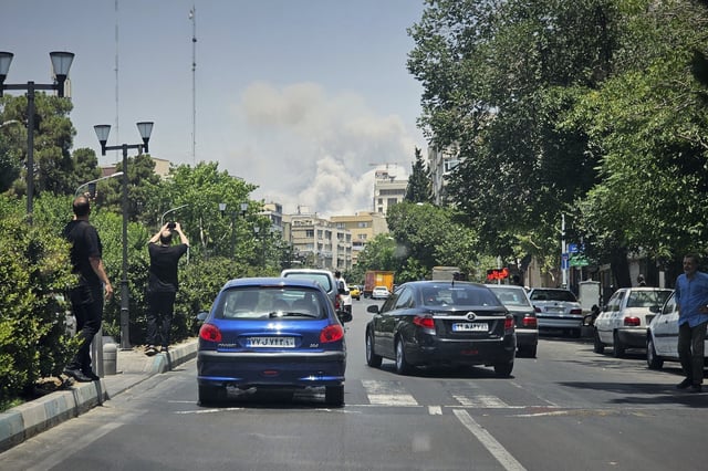 FILE - People take pictures of smoke rising from an Israeli strike in Tehran, Iran, June 23, 2025. (AP Photo, File)