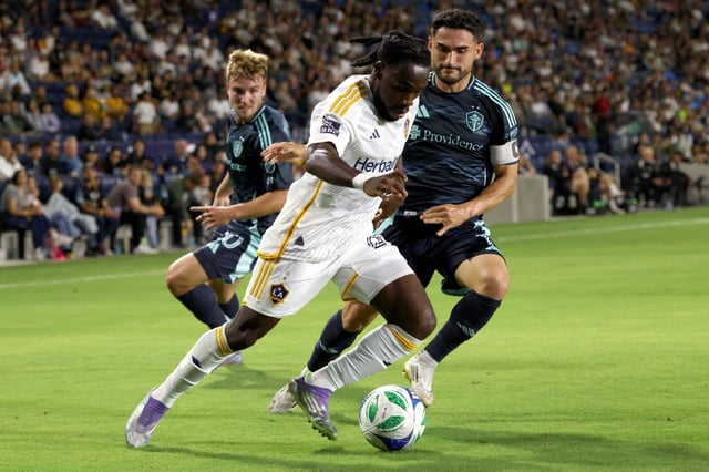 The Galaxy’s Joseph Paintsil, front, controls the ball while defended by Seattle’s Cristian Roldan during the first half Aug. 10, 2025, at Dignity Health Sports Park. (Photo by Raul Romero Jr., Contributing Photographer)