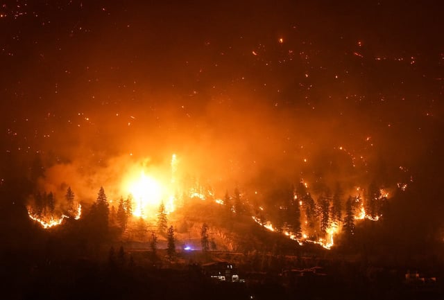 The McDougall Creek wildfire burns on the mountainside above lakefront homes in West Kelowna, B.C., on Friday, Aug. 18, 2023. THE CANADIAN PRESS/Darryl Dyck