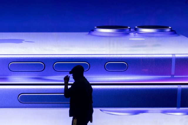 A man walks past an advertisement for an Apple iPhone at an Apple Inc. store in central London, on January 27, 2025.
