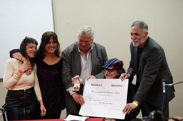 Charly García recibe el Doctorado Honoris Causa de la UBA rodeado por autoridades de la Facultad de Filosofía y Letras. (X @constat_concept).