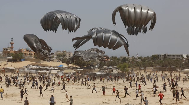 Gazans flock to the area where humanitarian aid is dropped from the air in Deir al Balah on Aug. 19, 2025. (Mohammed Nassar/Anadolu via Getty Images)