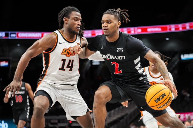 Mar 11, 2025; Kansas City, MO, USA; Cincinnati Bearcats guard Jizzle James (2) drives to the basket around Oklahoma State Cowboys guard Jamyron Keller (14) during the second half at T-Mobile Center. Mandatory Credit: William Purnell-Imagn Images/ File Photo