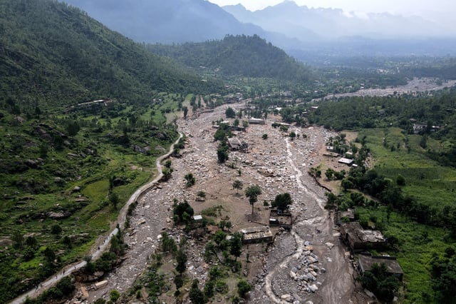 An aerial view shows houses partially submerged in sludge along a riverbed in the aftermath of flash floods at the Buner district of Khyber Pakhtunkhwa province, on August 17, 2025.