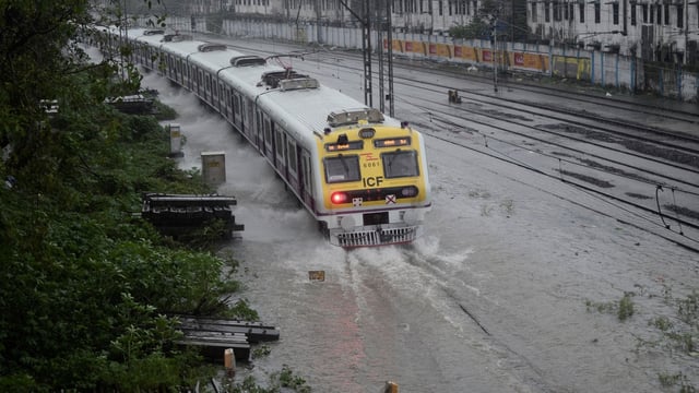 A train moves on submerged railway tracks after heavy rains in Mumbai on August 19.