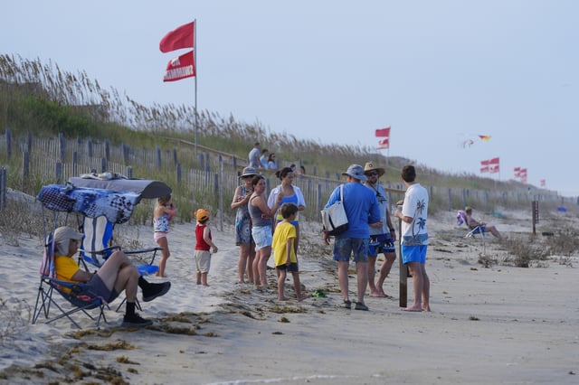 Red flags, indicating swimming is prohibited, are raised at the beach in Duck, N.C., Tuesday, Aug. 19, 2025, as precautions are taken ahead of Hurricane Erin. (AP Photo/Pablo Martinez Monsivais)