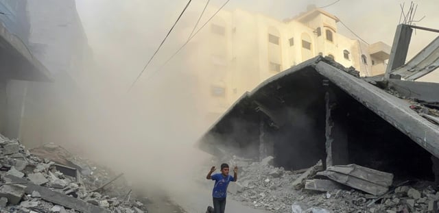Un garçon palestinien fuit en courant des frappes aériennes à Jabalia, dans le nord de la bande de Gaza, le 19 août 2025