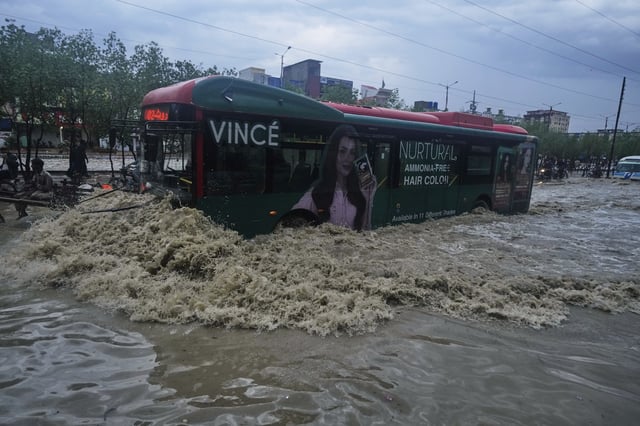 A bus drives through a flooded road after heavy rainfall in Karachi, Pakistan, Tuesday, Aug. 19, 2025. (AP Photo/Fareed Khan)