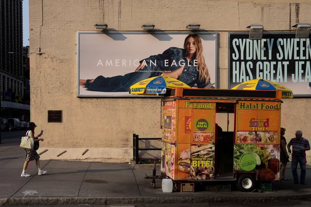 A woman walks near an American Eagle ad campaign featuring Sydney Sweeney in New York City, U.S., August 4, 2025. REUTERS/David 'Dee' Delgado/File Photo