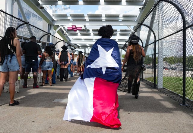 Wearing a Texas flag, a Beyoncé fan makes their way to the concert at NRG Stadium in Houston on Saturday, June 28, 2025. Texas is ranked 8th overall in a WalletHub survey of the most "fun" states in the U.S. The states 1st in four categories, including restaurant, movie theater, amusement park and fitness center options.