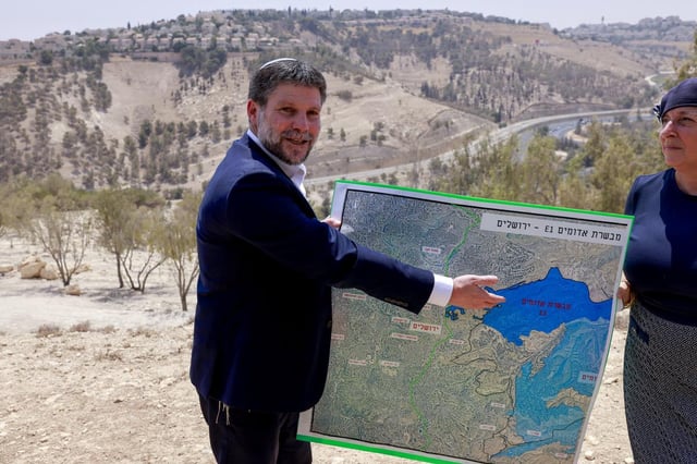 Le ministre israélien des Finances d’extrême droite, Bezalel Smotrich, montre une carte d’une zone proche de la colonie de Maale Adumim, un corridor terrestre connu sous le nom d’«E1», à l’extérieur de Jérusalem, en Cisjordanie occupée, le 14 août 2025.