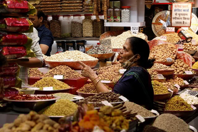 A woman buys dry fruits from a shop in a wholesale market in the old quarters of Delhi, India, April 2, 2025. REUTERS/Priyanshu Singh/File Photo