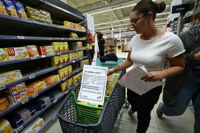 Des membres des syndicats agricoles FDSEA 72 et Jeunes Agriculteurs (JA), retirent des rayons des produits contenant de l'acétamipride, un pesticide néonicotinoïde, lors d'une opération de protestation dans un supermarché de Mundolsheim, le 20 août 2025 dans le Bas-Rhin