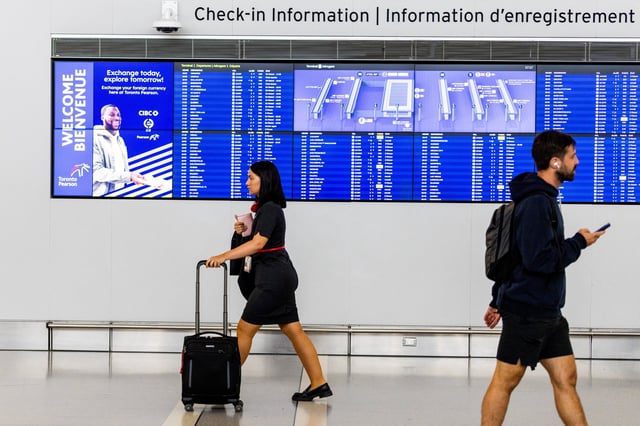 An Air Canada flight attendant arrives at Toronto Pearson International Airport, following the end of the Air Canada labour strike, in Mississauga, Ontario, Canada, August 19, 2025. REUTERS/Carlos Osorio