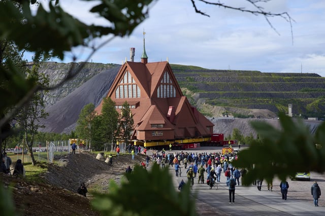 FILE - People gather outside the Kiruna Church, a Sami style wooden Swedish Lutheran church, called Kiruna Kyrka in Swedish, in Kiruna, Sweden, Tuesday, Aug. 19, 2025, during its move along a 5-kilometer (3-mile) route east to a new city center as part of the town's relocation. (AP Photo/Malin Haarala, File)