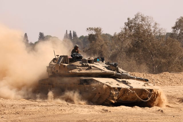 Las tropas israelíes conducen un tanque cerca de la valla fronteriza de Israel con la Franja de Gaza el 19 de agosto de 2025